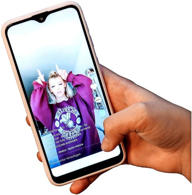 Ein Tiktok-Video auf einem Smartphone:...n nehmen sich ber die App selbst auf.  | Foto: Jens Kalaene (dpa)