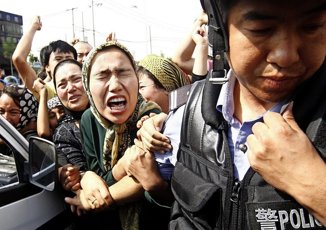 Chinesische Polizisten nehmen Uiguren ...injiang whrend der Unruhen 2009 fest.  | Foto: Oliver Weiken