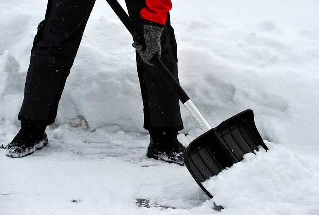 Eine Frau schippt Schnee von einem Fuweg.  | Foto: Patrick Pleul