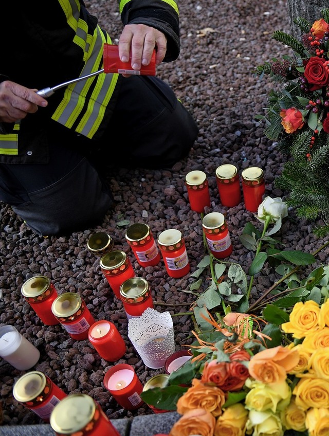 Ein Feuerwehrmann entzndet am Tatort,... Kerze fr seinen getteten Kameraden.  | Foto: Stefan Puchner