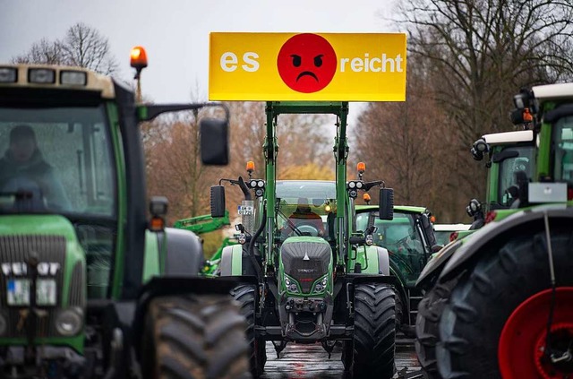 An einem Traktor hngt ein Plakat mit der Aufschrift: &#8222;Es reicht&quot;.  | Foto: Guido Kirchner (dpa)