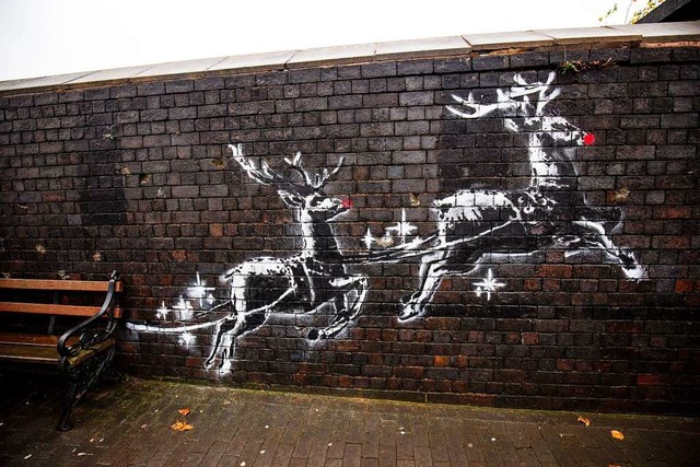 Ein neues Banksy-Kunstwerk mit dem Tit...henden Bank vorbei zu ziehen scheinen.  | Foto: Jacob King (dpa)
