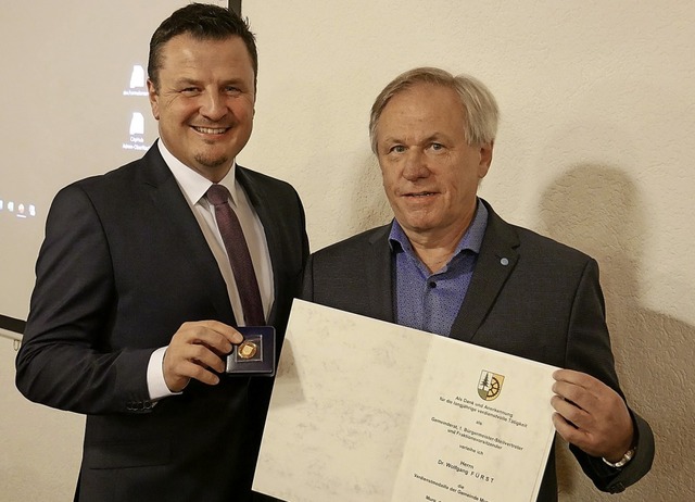 Die  Verdienstmedaille der  Gemeinde  ...ermeister Adrian Schmidle berreicht.   | Foto: Michael Gottstein