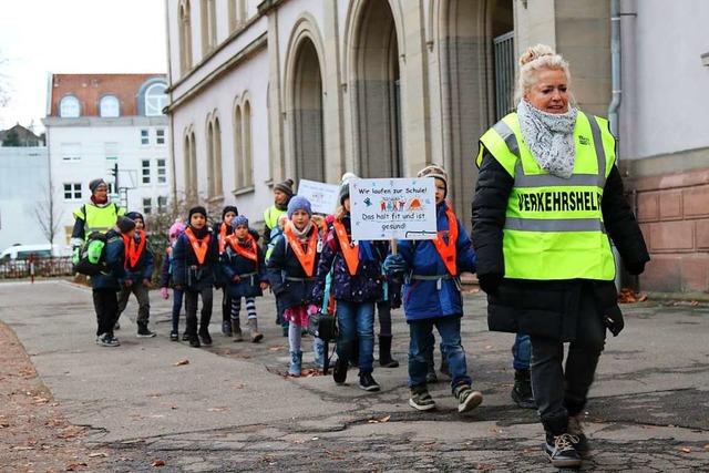 Ein laufender Schulbus mit Transparenten vor der Hebelschule in der Stadt  | Foto: Katharina Bartsch