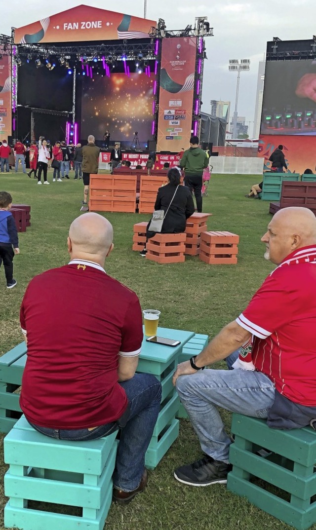 Liverpool-Fans sitzen bei einem Bier  in der Fanzone in Doha.  | Foto: Jan Kuhlmann (dpa)