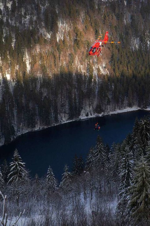 Ein Rettungshubschrauber fliegt mit ei...warzwald über den Feldsee am Feldberg.  | Foto: Michael Corona (dpa)