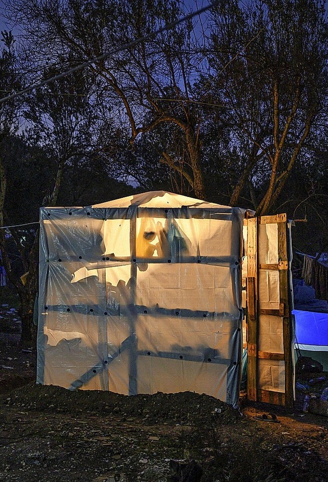 Plastikplanen und Holz bilden eine Unterkunft nahe dem Lager Moria auf Lesbos.  | Foto: Angelos Tzortzinis (dpa)