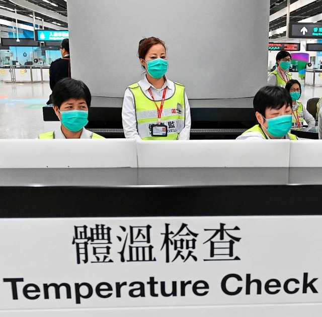Mitarbeiter des Gesundheitswesens kont...Reisende auf ihren Gesundheitszustand.  | Foto: dpa