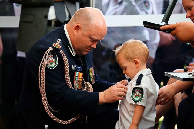 Shane Fitzsimmons  berreicht dem Sohn...szeichnung fr seinen mutigen Einsatz.  | Foto: NSW Rural Fire Service (dpa)
