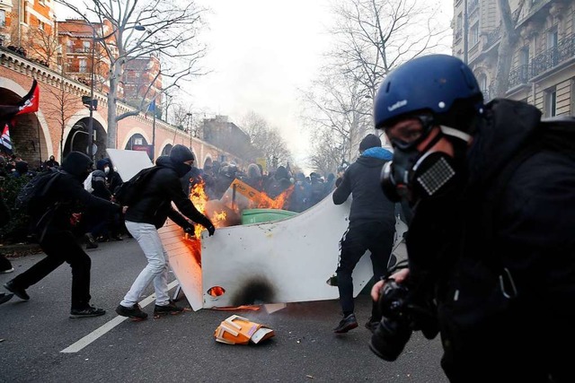 Vermummte Jugendliche setzen bei einer...tration in Paris Gegenstnde in Brand.  | Foto: Francois Mori (dpa)