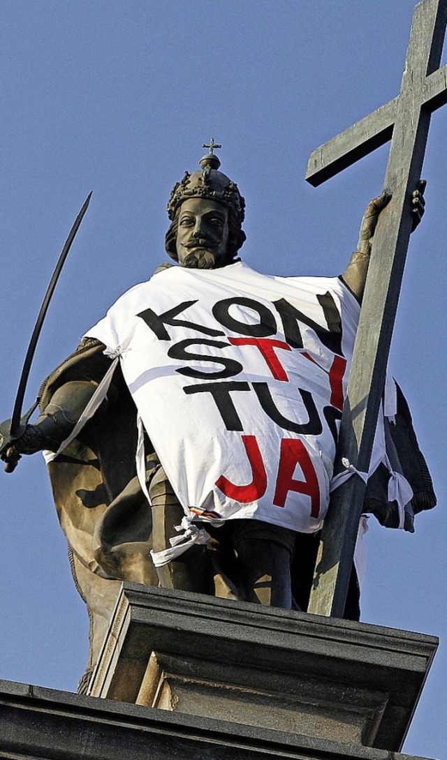 Die Statue von Knig Sigismund III.   ...  mit einem Protest Banner eingehllt.  | Foto: Czarek Sokolowski (dpa)