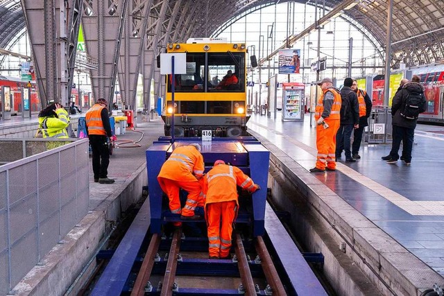 Mitarbeiter der Deutschen Bahn reparie...n beschdigten Prellbock in Frankfurt.  | Foto: Andreas Arnold (dpa)