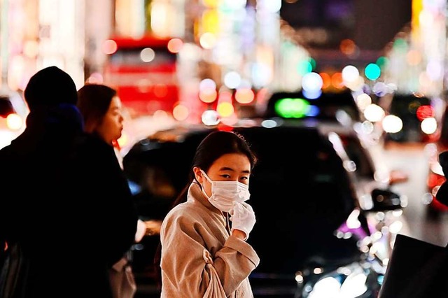 Ein Passant in Wuhan trgt Mundschutz....ankheit erkrankt, 56 daran verstorben.  | Foto: CHARLY TRIBALLEAU (AFP)