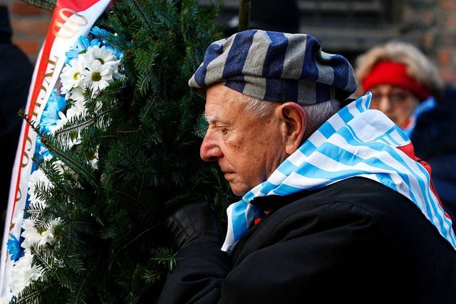 Ein berlebender des Holocaust trgt whrend der Gedenkfeier einen Kranz.   | Foto: Czarek Sokolowski (dpa)