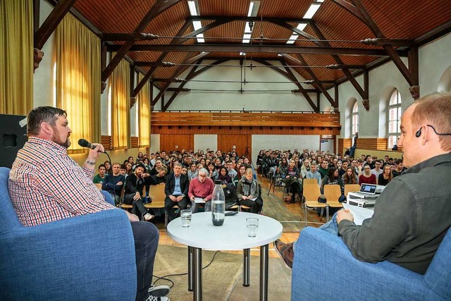 Manuel Bauer (links) im Gesprch mit G...alten Halle des Stdtischen Gymnasiums  | Foto: Sandra Decoux-Kone