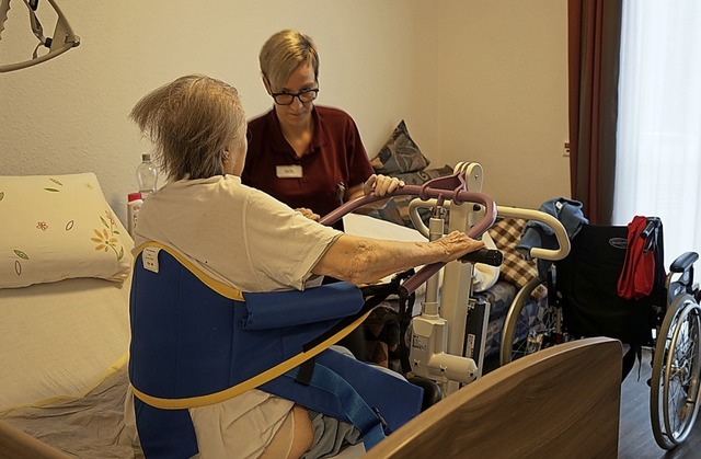 Altenpflegerin Steffi Kootz hilft einer Bewohnerin in die Aufstehhilfe.  | Foto: Verena Wehrle