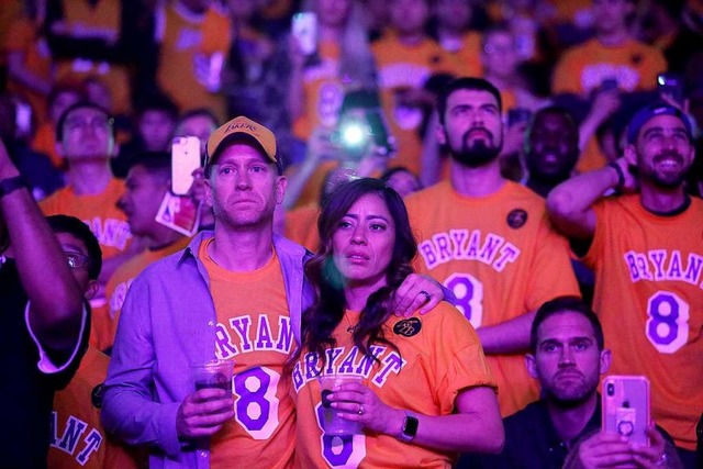 Fans trauern, whrend in der Halbzeit ...verstorbenen Kobe Bryant gezeigt wird.  | Foto: Ringo H.W. Chiu (dpa)