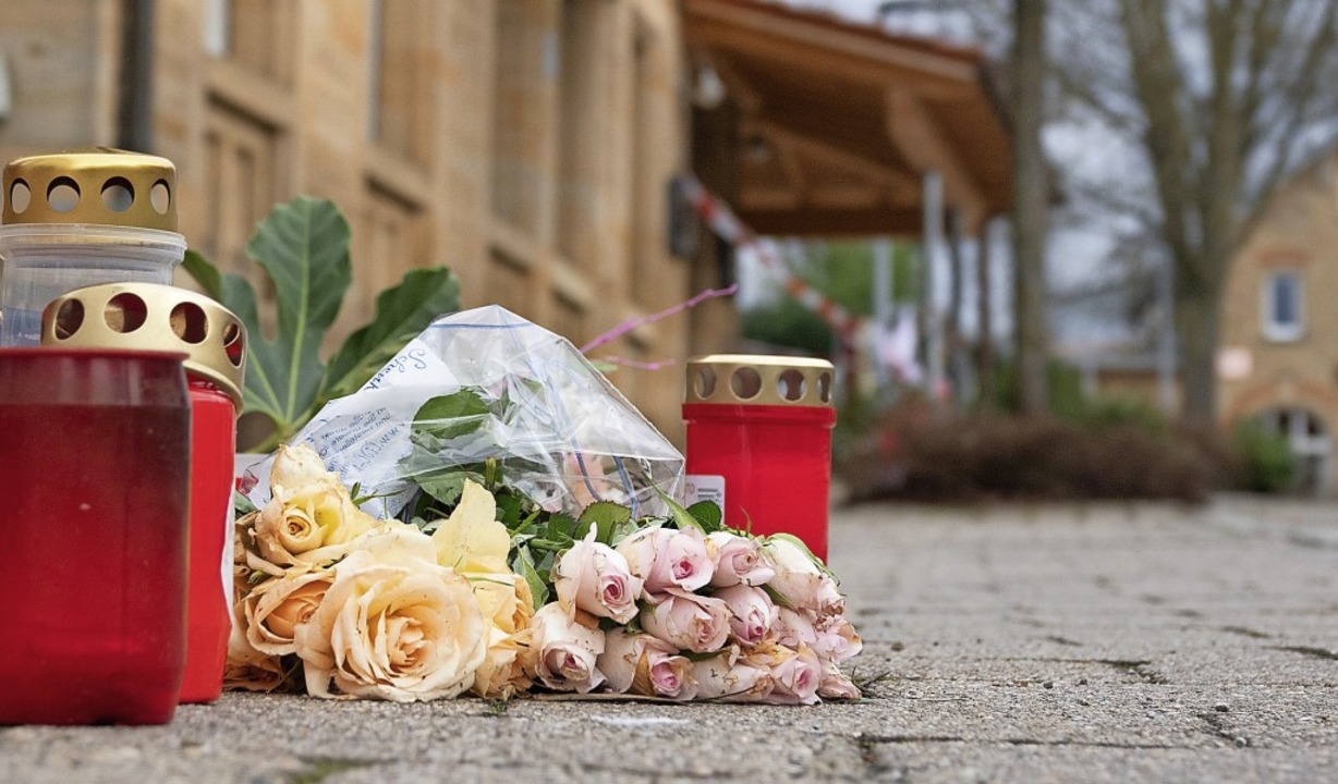 Vor einem Haus erinnern niedergelegte Rosen und Kerzen an die Bluttat.   | Foto: Gregor Bauernfeind (dpa)