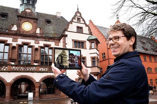 Rolf Mathis blendet zwischen historisc...ger Ansicht des Rathauses hin und her.  | Foto: Thomas Kunz