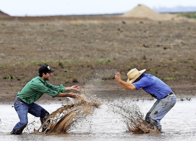 Endlich Wasser! Zwei Mnner plantschen...ftze, die der Regen hinterlassen hat.  | Foto: Peter Lorimer (dpa)