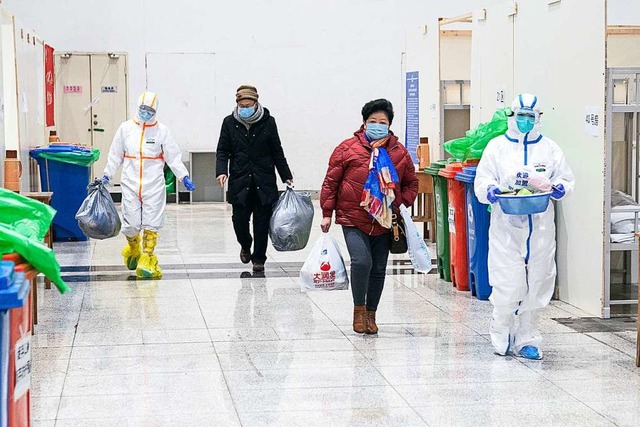 Medizinisches Personal im Schutzanzug ...urch die Flure von Wuhans Krankenhaus.  | Foto: Xiong Qi (dpa)