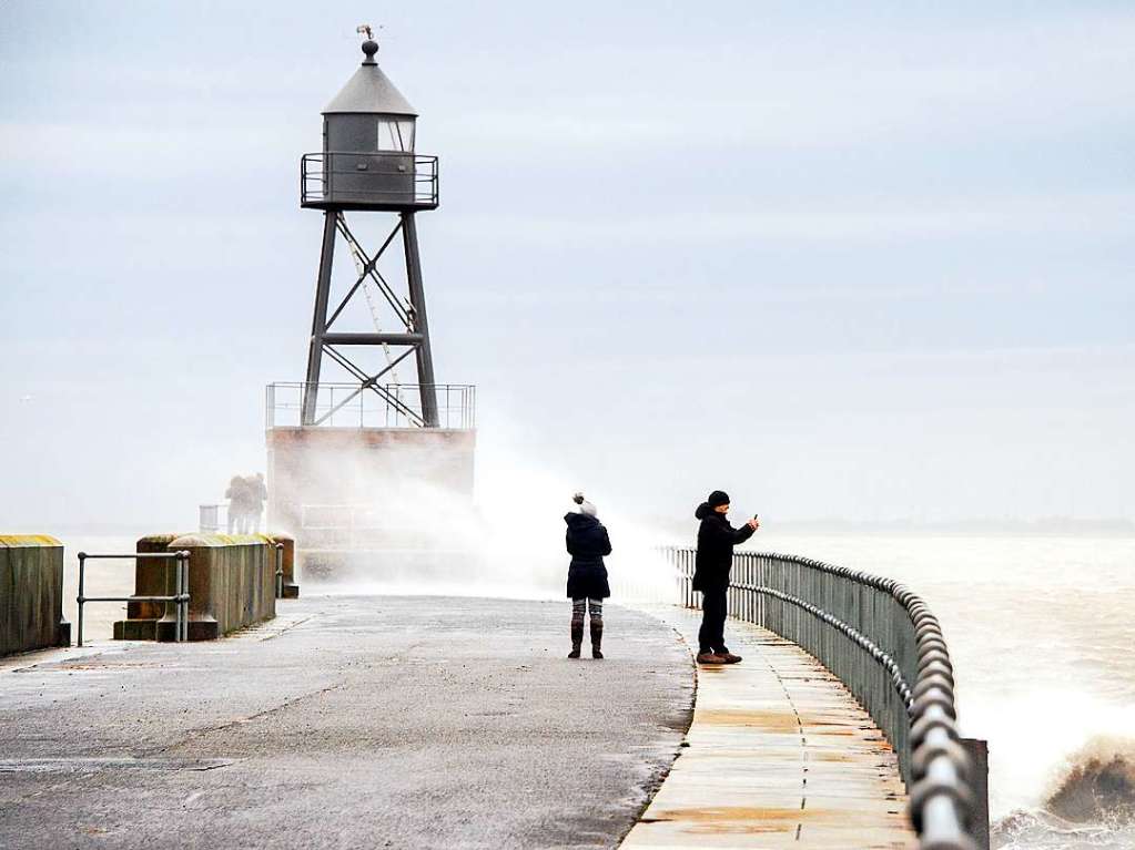 Passanten fotografieren den Wellengang whrend des Sturmtiefs „Sabine“ auf einer Mole am Querfeuer im Nordosten von Wilhelmshaven.