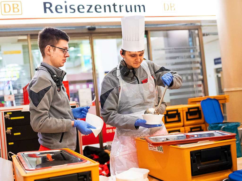 Ehrenamtliche Mitarbeiter eines Rettungsdienstes verteilten Schalen mit Suppe an gestrandete Reisende im Bahnhof von Hannover.