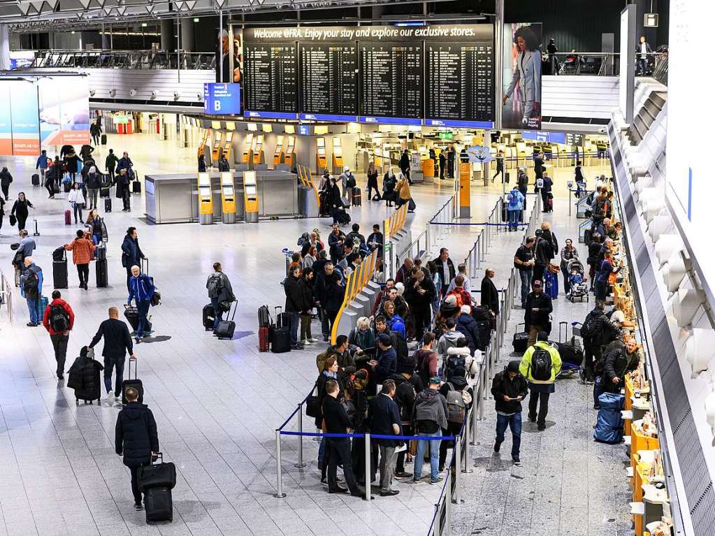 Menschen warten an einem Lufthansa-Schalter im Terminal 1 des Flughafens Frankfurt.