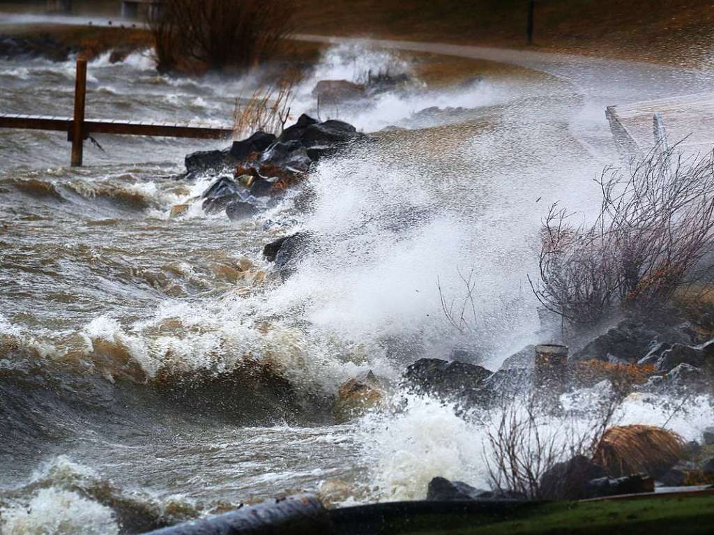 Das vom Sturm aufgepeitschte Wasser des Hopfensees im Allgu trifft auf die Uferpromenade.