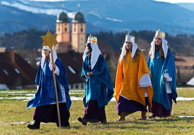 Vier Sternsinger laufen in St. Mrgen ber eine Wiese.  | Foto: Patrick Seeger