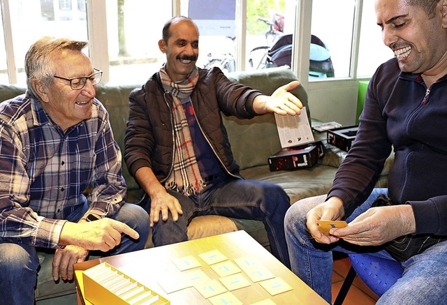 Norbert Adam (links) beim Sprachspiel mit zwei Caf-Besuchern  | Foto: Stadtverwaltung