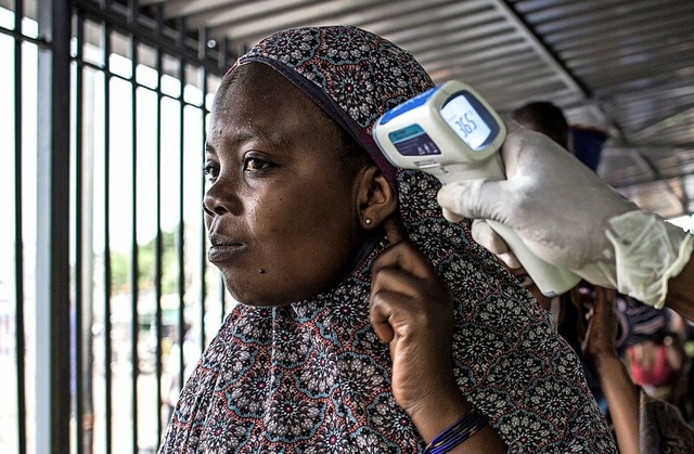 In einer Ebola-Screening-Station im Ko...Krpertemperatur einer Frau gemessen.   | Foto: JOHN WESSELS (AFP)