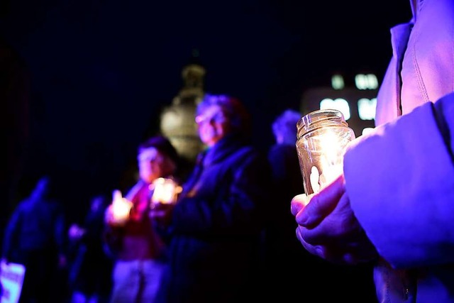 Gegendemonstranten halten Kerzen.  | Foto: Robert Michael (dpa)