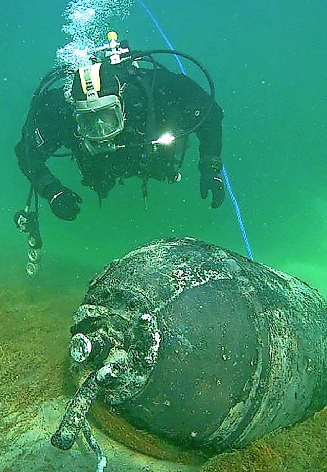 Ein Taucher der Polizei schwimmt im Bodensee um einen Sprengkrper.  | Foto: --- (dpa)