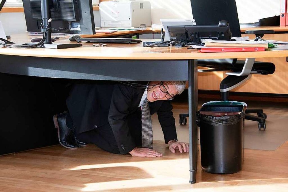 Müllheims Bürgermeister Martin Löffler versteckt sich zunächst unterm Schreibtisch, muss den Narren dann aber doch den Schlüssel überreichen. (Foto: Volker Münch) Müllheims Bürgermeister Martin Löffler versteckt sich zunächst unterm Schreibtisch, muss den Narren dann aber doch den Schlüssel überreichen. (Foto: Volker Münch)