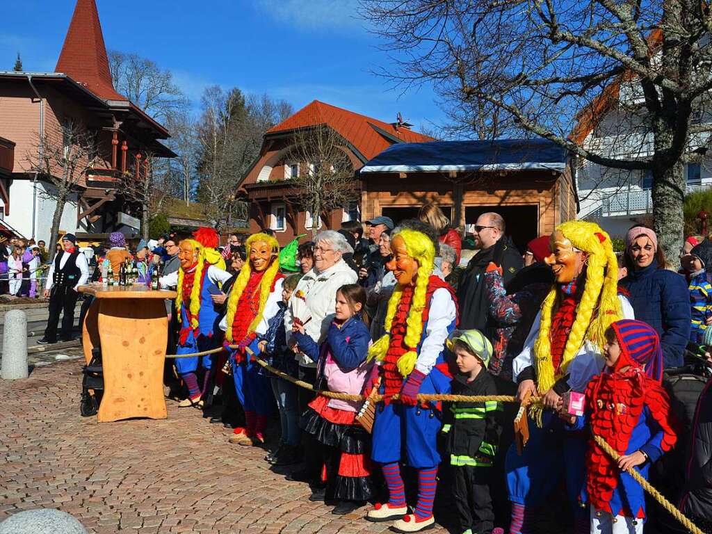 Glunkis und Zuschauer verfolgen das Stellen des Narrenbaums in Schluchsee.