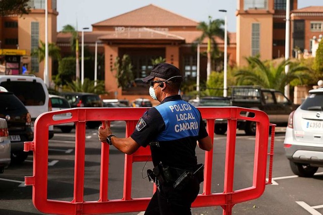 Ein Polizist setzt eine Sperre, die de... Adeje Palace auf Teneriffa blockiert.  | Foto: Uncredited (dpa)