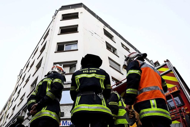 Feuerwehrleute an dem Wohnhaus im Stra...lage knnte den Brand ausgelst haben.  | Foto: PATRICK HERTZOG (AFP)