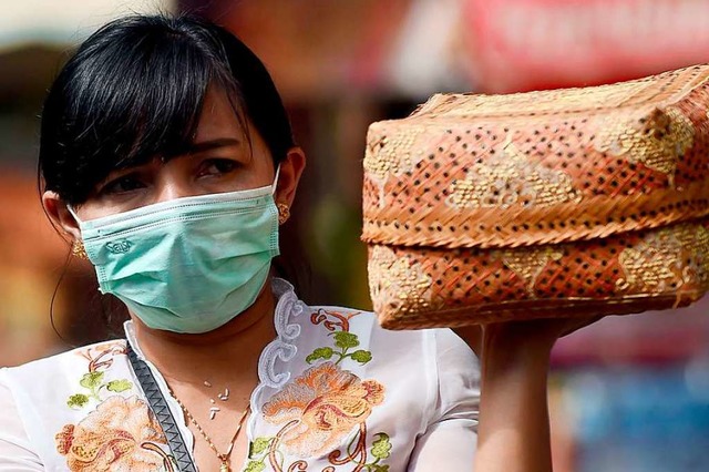 Auch auf der Insel Bali sind viele Menschen mit Mundschutz unterwegs.  | Foto: SONNY TUMBELAKA (AFP)