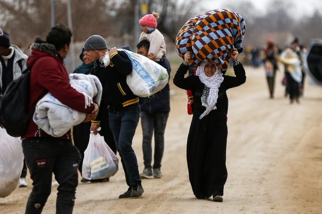 Migranten tragen an der trkisch-griechischen Grenze ihre Habseligkeiten.  | Foto: Emrah Gurel (dpa)