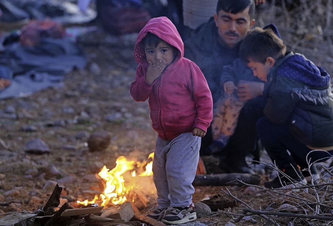 Vor allem Kinder sind in einer bedrohl... auf der Insel Lesbos an einem Feuer.   | Foto: Marios Lolos (dpa)