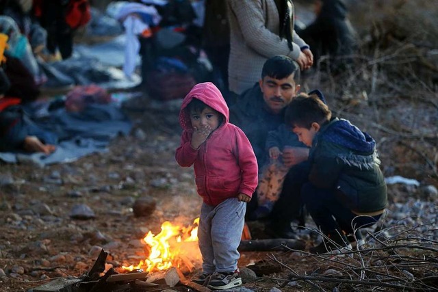 Vor allem Kinder sind in einer bedrohl... auf der Insel Lesbos an einem Feuer.   | Foto: Marios Lolos (dpa)
