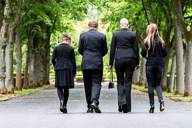 Trauernde Menschen laufen ber einen Friedhof.  | Foto: Kzenon (stock.adobe.com)