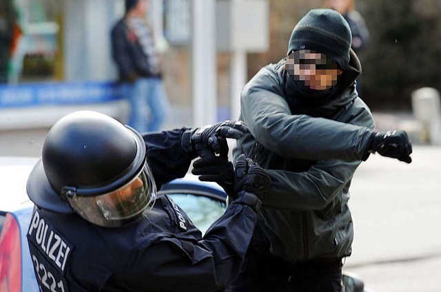 Ein gewaltttiger Demonstrant schlgt einen Polizeibeamten nieder. (Archivbild)  | Foto: Carsten Rehder (dpa)