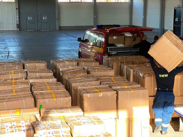 THW und Feuerwehr verladen Pakete mit Schutzausrstung aus China  | Foto: Stadt Offenburg