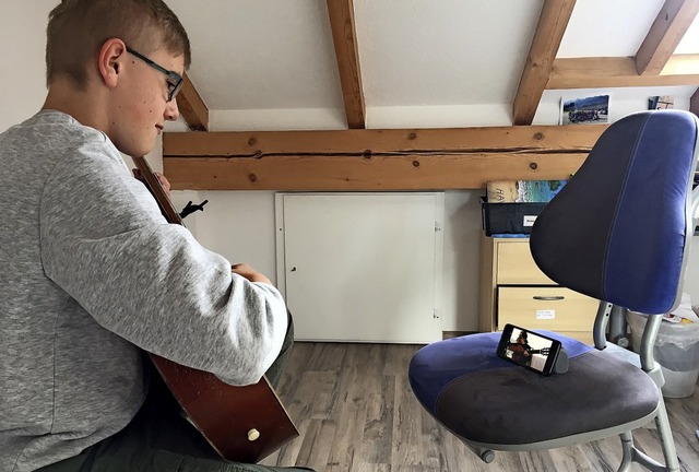 Simon Harder aus Lenzkirch bei einem Gitarrenunterricht via Handy.  | Foto: Ursula Harder