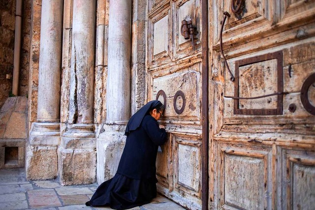 Eine Nonne betet vor der verschlossene...us Christus an dem Ort begraben wurde.  | Foto: Ariel Schalit (dpa)