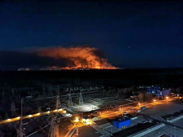 Am Horizont steigen Rauchschwaden von ... um das Kernkraftwerk Tschernobyl auf.  | Foto: Uncredited (dpa)
