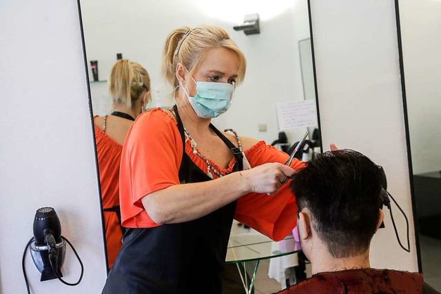 Diese Friseurin in Brssel arbeitet we...ereits mit einem Mund-und-Nasenschutz.  | Foto: Thierry Roge (dpa)