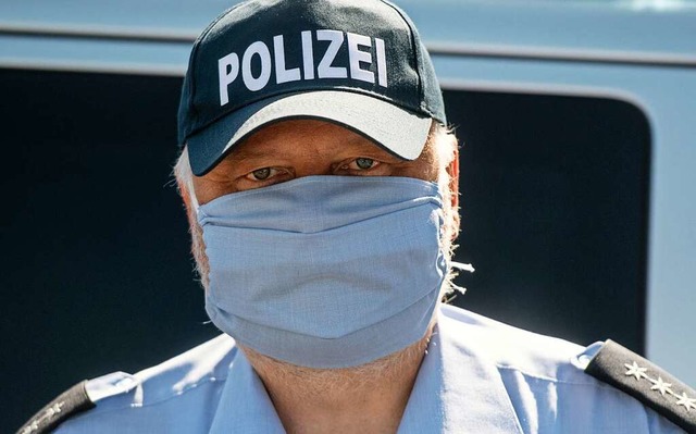 Polizist mit Mundschutz (Symbolfoto)  | Foto: Bernd Thissen (dpa)